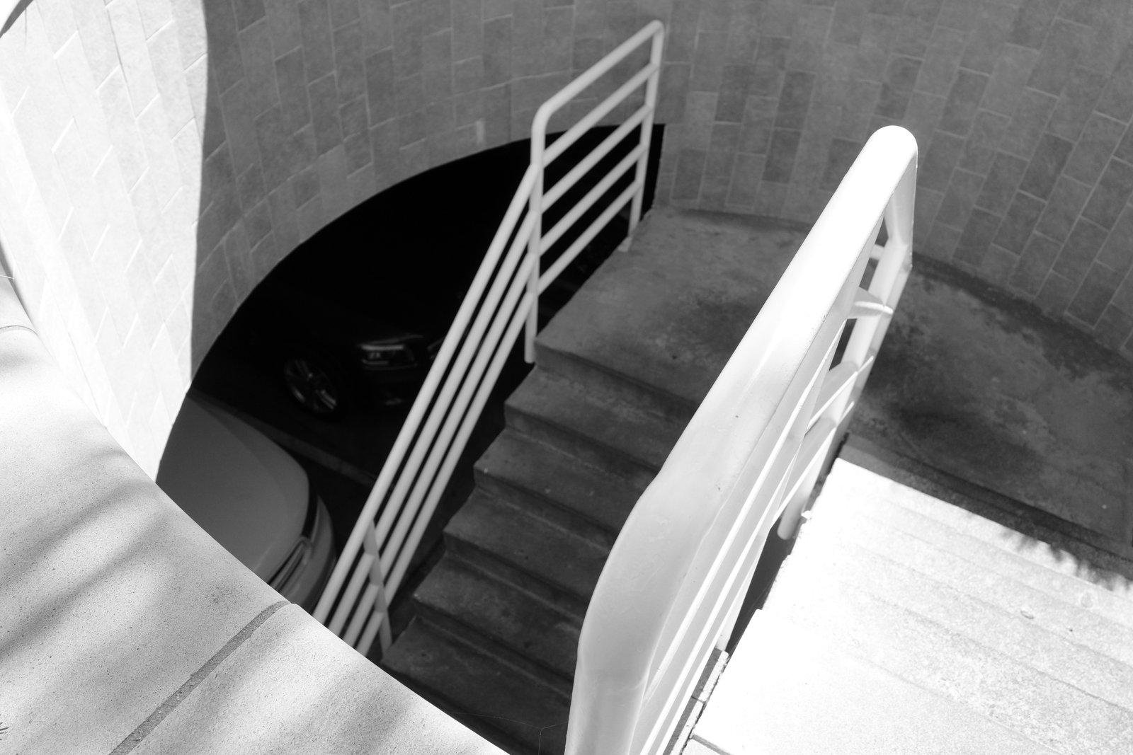A spiral stair descends around a dark central opening.