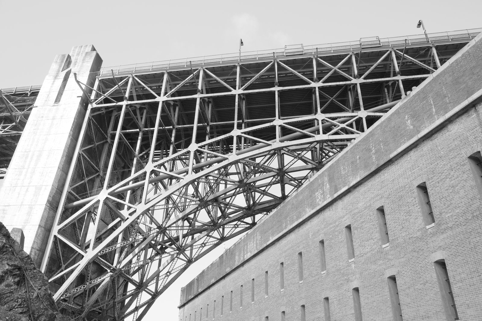 Bridge steelwork crosses diagonally beside masonry.