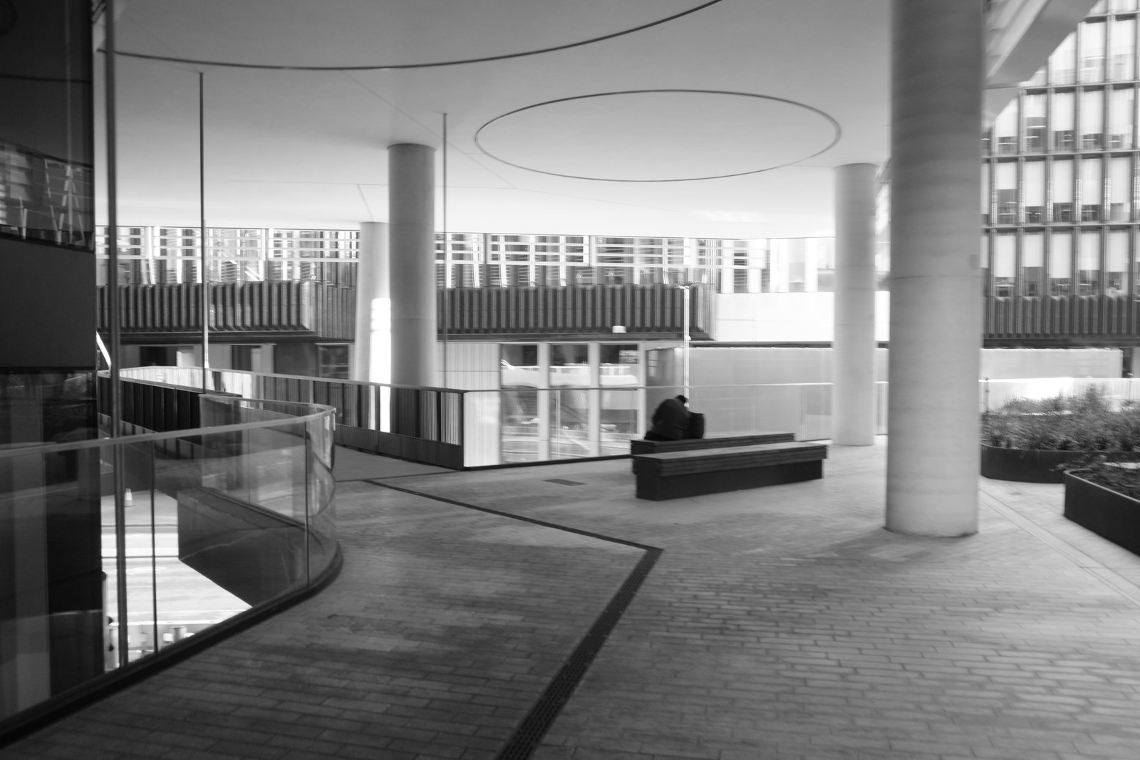 Slender columns, curved railings and a circular ceiling detail surround an open passage.