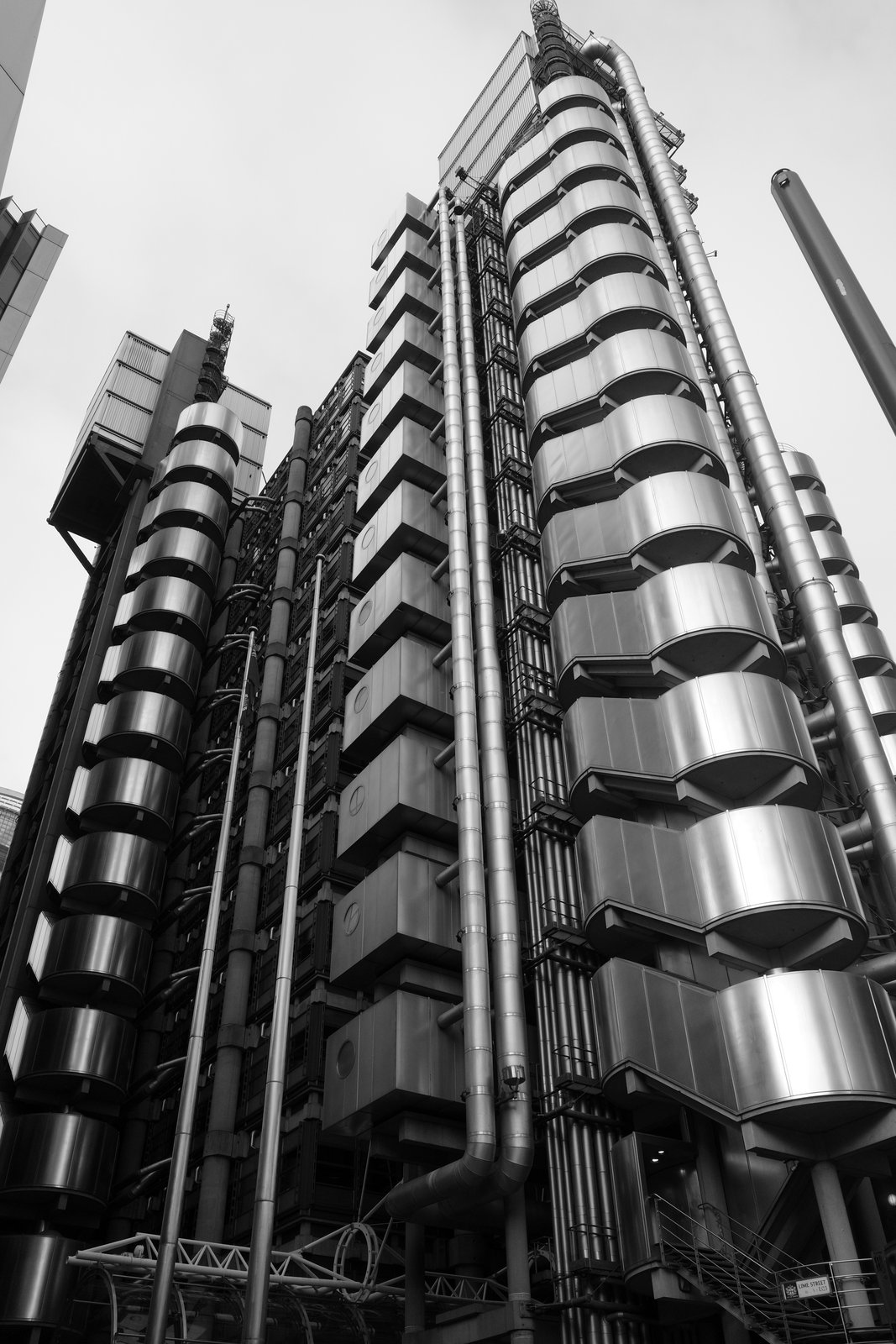 Curved exposed pipes climb the outside of a tall building.