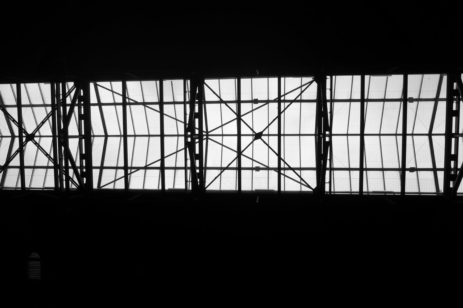 A bright industrial skylight crosses a dark ceiling.