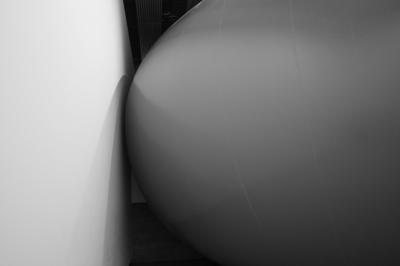 A large inflated curved volume nearly touches a wall.