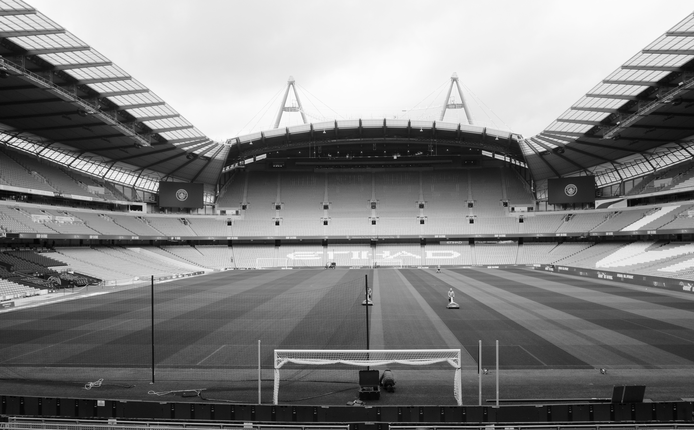 A centered view across an empty stadium pitch toward opposite stands.
